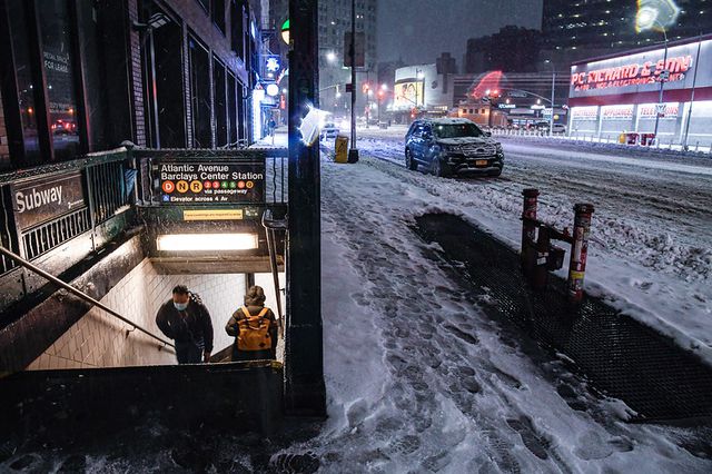 Commuters on the subway stairs as snow falls aboveground at Atlantic Av-Barclays Center in Brooklyn.
